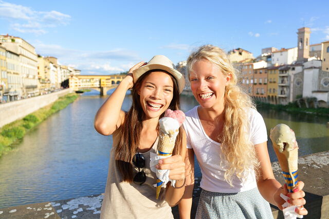 Des amis mangent des glaces le long de l'Arno