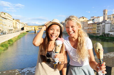Des amis mangent des glaces le long de l'Arno