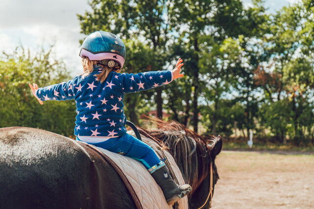 Une petite fille qui fait de l'équitation