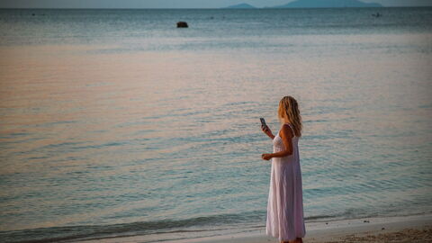 Femme au téléphone sur une plage