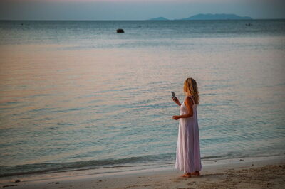 Femme au téléphone sur une plage